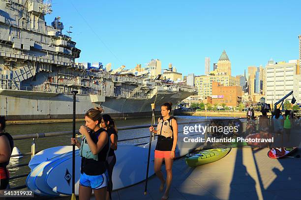 hell's kitchen - pier 84 on the hudson river. kayaking under the intrepid museum ship - pier 84 stock pictures, royalty-free photos & images