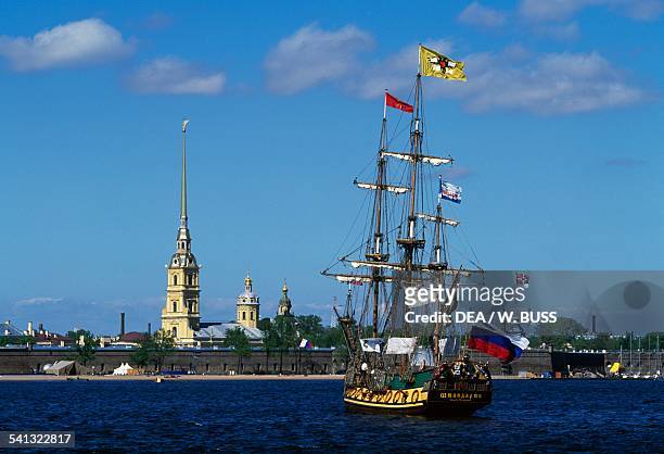 Former three-masted schooner on the Neva river with the Peter and Paul Fortress in the background, St Petersburg , Russia.