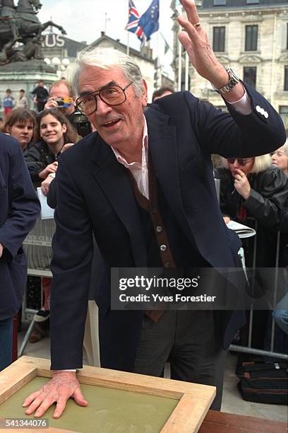 Gregory Peck makes hand prints in wet cement at the 14th Detective Film Festival in Cognac, France.