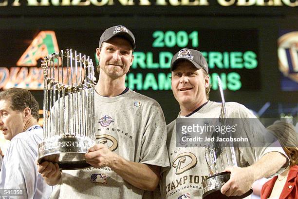 Co-MVP winners Randy Johnson and Curt Schilling of the Arizona Diamondbacks hold the trophys after winning the World Series over the New York Yankees...