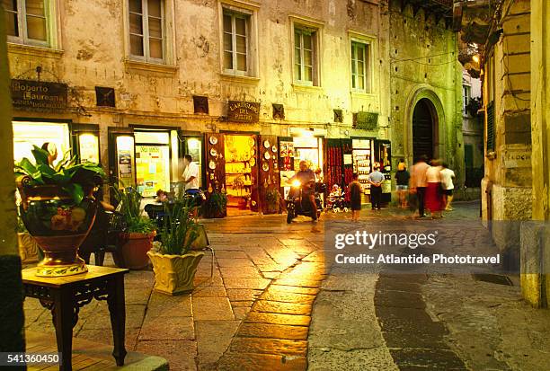 shops in alley at night - calabria stock pictures, royalty-free photos & images