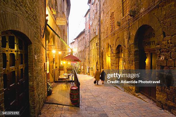 woman walking down alley - volterra fotografías e imágenes de stock