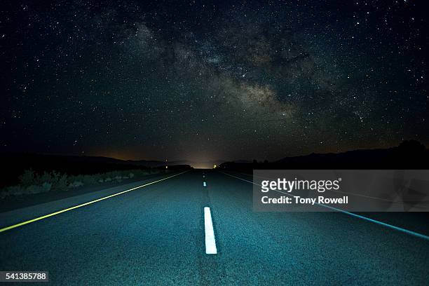 the milky way rises over a remote section of highway 395 in california's eastern sierra - autostrada foto e immagini stock