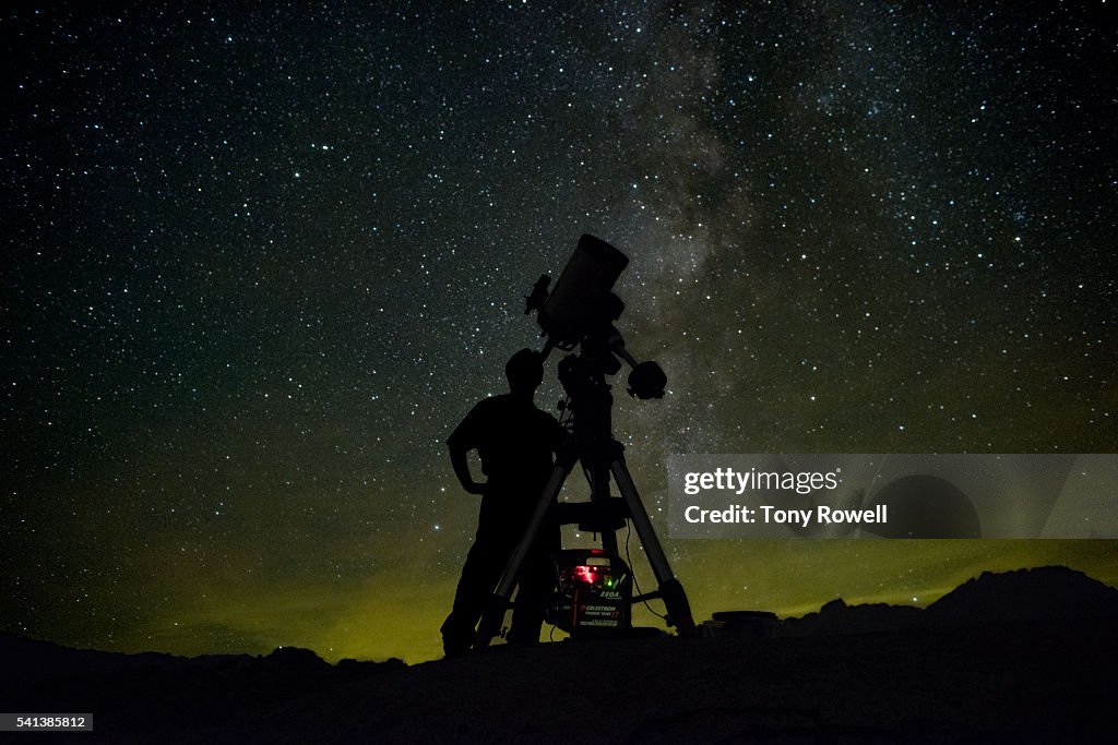 Astronomer with telescope milky way