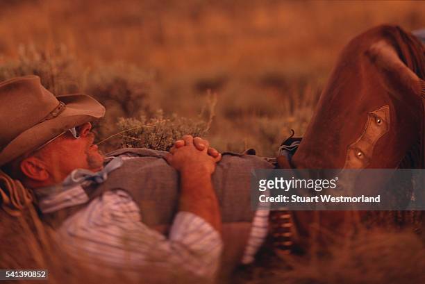 cowboy relaxing in a field - cowboy sleeping stock pictures, royalty-free photos & images