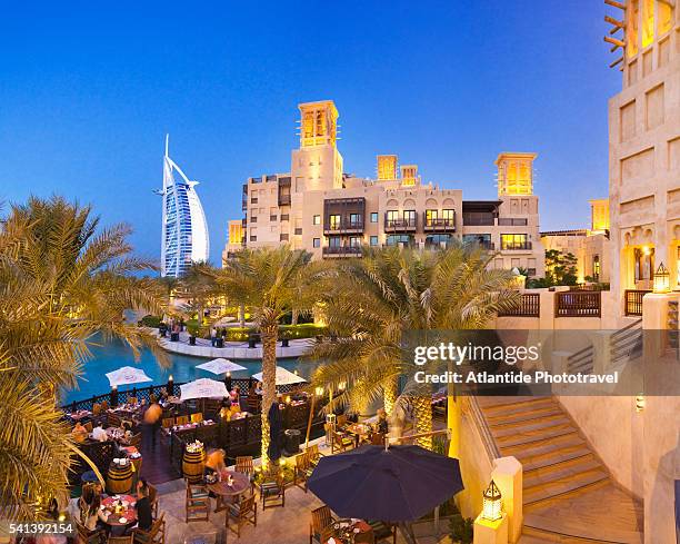 restaurant at souk madinat jumeirah with burj al arab in background - madinat jumeirah hotel stock pictures, royalty-free photos & images