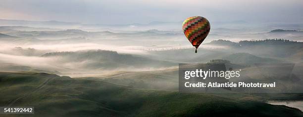 hot air balloon over crete senesi area of tuscany - mongolfiera foto e immagini stock