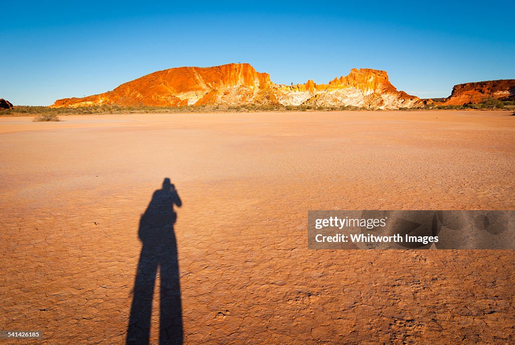 Shadow of man on claypan. Rainbow Valley Australia