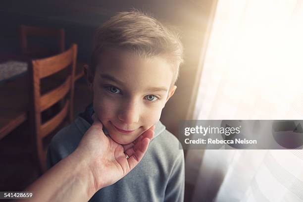 mother's hand cupping son's chin - ungewöhnliche perspektive stock-fotos und bilder