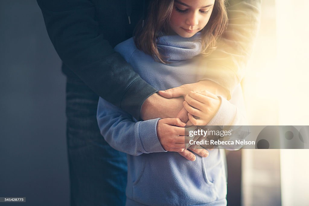 Father's arms wrapped around daughter