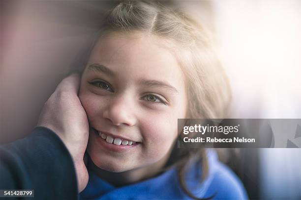 father's hand cupping daughter's cheek - hazel bond stock pictures, royalty-free photos & images