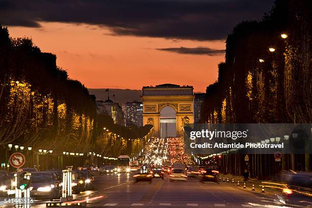 champs-elysees and the arc de triomphe at night - arc de triomphe paris stock pictures, royalty-free photos & images