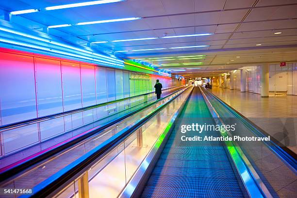 man on moving walkway at munich airport - travolator stock pictures, royalty-free photos & images