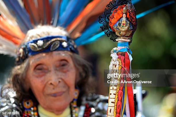 Josefina Garcia de Alvarado holds a Virgen de Guadalupe on the end of her staff during a mural dedication at La Raza Park on Sunday, June 20, 2016....