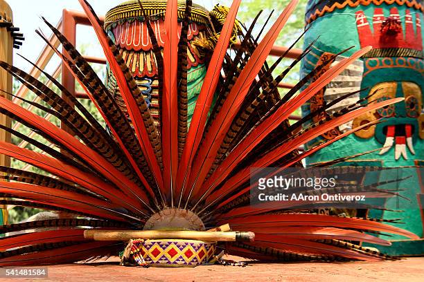 Traditional headdress lays in the shade near the drums during a mural dedication at La Raza Park on Sunday, June 20, 2016. The Denver Arts and Venue'...