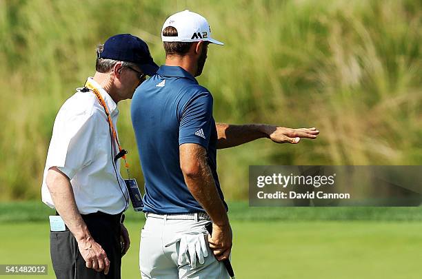 Dustin Johnson of the United States chats with a rules official on the fifth green during the final round of the U.S. Open at Oakmont Country Club on...