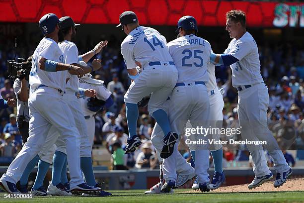 Scott Van Slyke, Enrique Hernandez, Will Venable, Joc Pederson and their Los Angeles Dodgers teammates surround teammate Yasmani Grandal to celebrate...