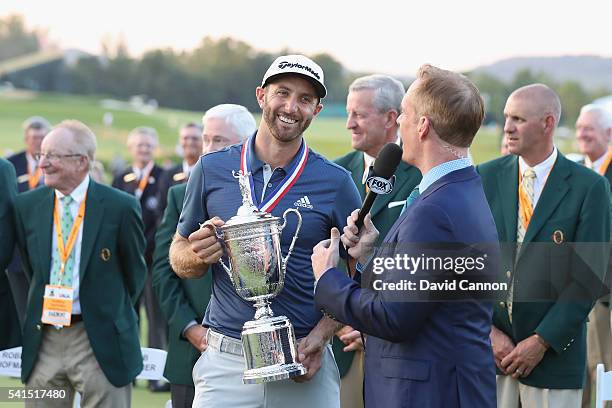 Dustin Johnson of the United States poses with the winner's trophy alongside Joe Buck of Fox Sports after winning the U.S. Open at Oakmont Country...