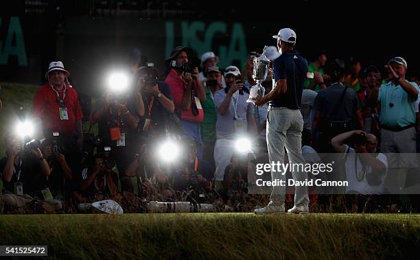 Dustin Johnson, Mark Dinham of the United States poses with the winner's trophy after winning the U.S. Open at Oakmont Country Club on June 19, 2016...