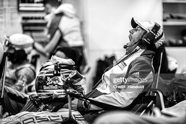 In this handout image provided by Red Bull, Porsche LMP1 driver Mark Webber of Australia yawns while waiting for his next stint in the early hours of...