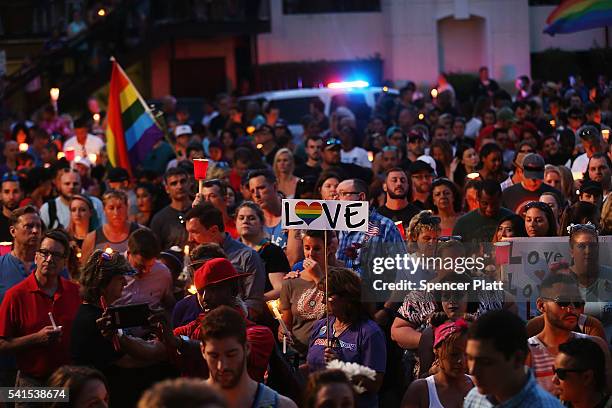 People attend a memorial service on June 19, 2016 in Orlando, Florida. Thousands of people are expected at the evening event which will feature...