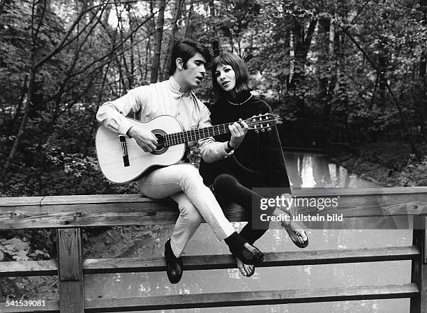 Ofarim, Esther *-Saengerin, Schauspielerin, Israel - mit ihrem Mann Abi, beide sitzen auf einem Brueckengelaender und singen, Abi spielt Gitarre- 1966