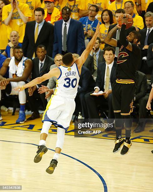 Cleveland Cavaliers guard Kyrie Irving makes a three-point shot over Golden State Warriors guard Stephen Curry to take the lead in the final moments...