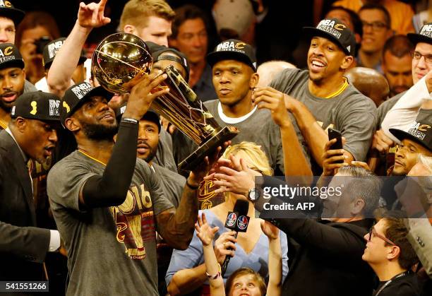 Cleveland Cavaliers forward LeBron James hoists the Larry O'Brien trophy after defeating the Golden State Warriors to win the NBA Finals on June 19,...