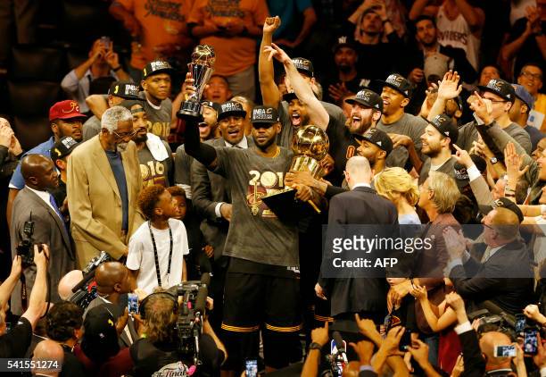 Cleveland Cavaliers forward LeBron James hoists the Larry O'Brien and the Finals MVP trophies after defeating the Golden State Warriors to win the...