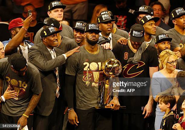 Cleveland Cavaliers forward LeBron James reacts while holding the Larry O'Brien trophy after defeating the Gold State Warriors to win the NBA Finals...
