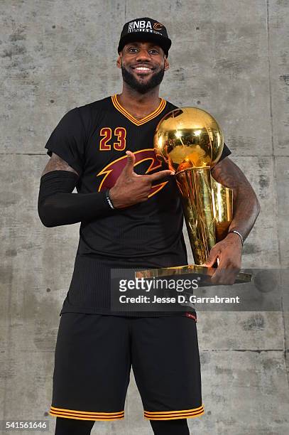 LeBron James of the Cleveland Cavaliers poses for a portrait with the World Championship Trophy after winning the NBA Championship against the Golden...