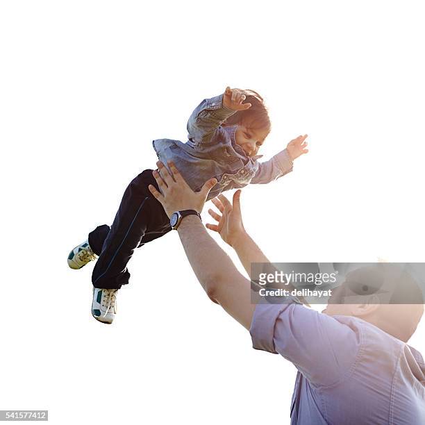father throwing son into air - dad throwing kid in air stockfoto's en -beelden