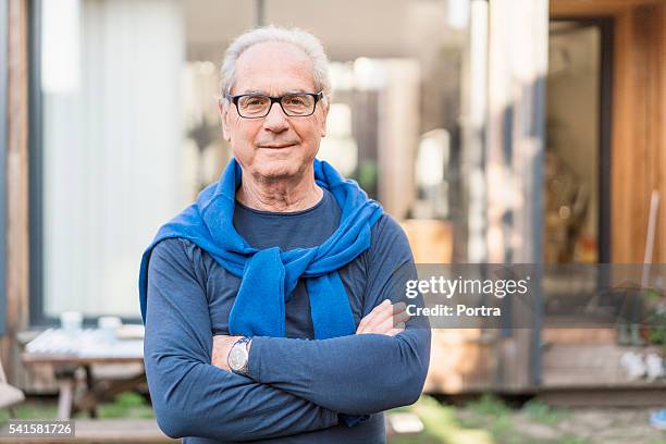 confiant homme senior avec les bras croisés dans l'arrière-cour - septuagénaire photos et images de collection