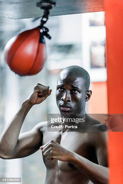 aggressive boxer practicing in health club - punching ball stock pictures, royalty-free photos & images