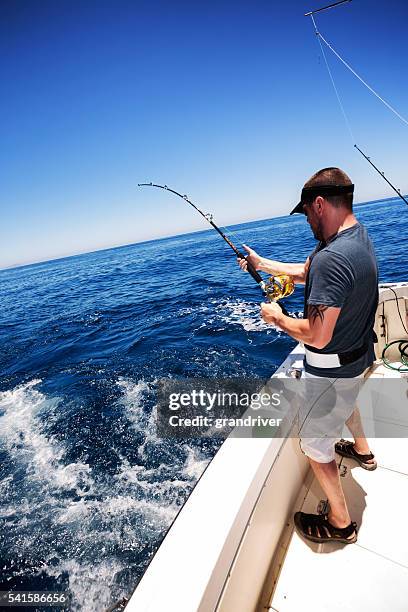 uomo cattura di pesci di grandi dimensioni oceano - industria della pesca foto e immagini stock