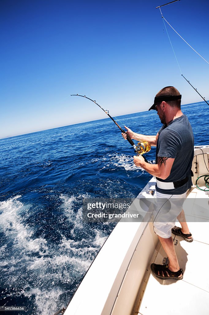 Man Catching Big Fish in Ocean