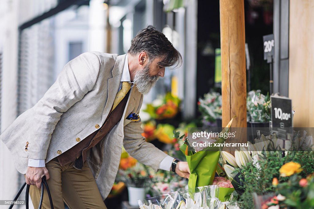 成熟した男性の花のフラワーショップで購入