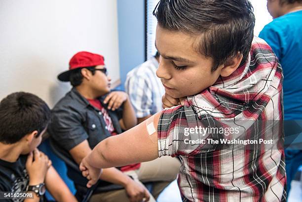 Abraham Vidaurre checks his arm after receiving an HPV vaccination at Amistad Community Health Center in Corpus Christi, Texas on Friday May 27,...