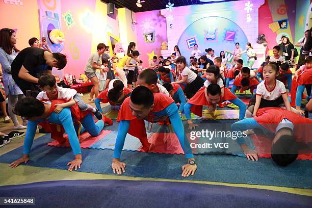 Fathers dressed as Supermen carrying their children on the back to compete push-ups to celebrate Father's Day on June 19, 2016 in Hangzhou, Zhejiang...