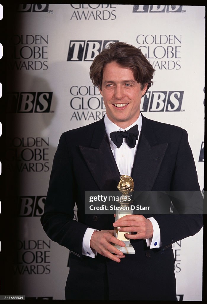 Actor Hugh Grant holds his Golden Globe Award for Best Actor in a