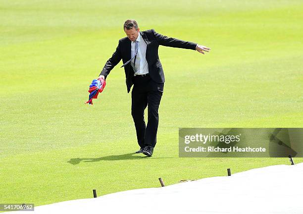 Sky Sports cricket presenter Dominic Cork walks through puddles on the pitch before the 1st Women's Royal London ODI match between England and...