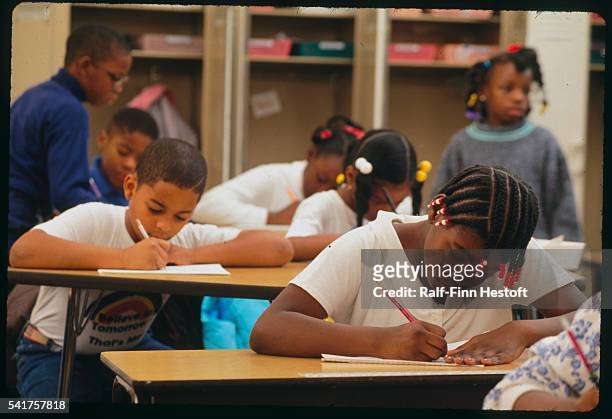 Chicago, Illinois: Nine and ten year old children in class while learning cursive writing and reading at the Corporate Community School.