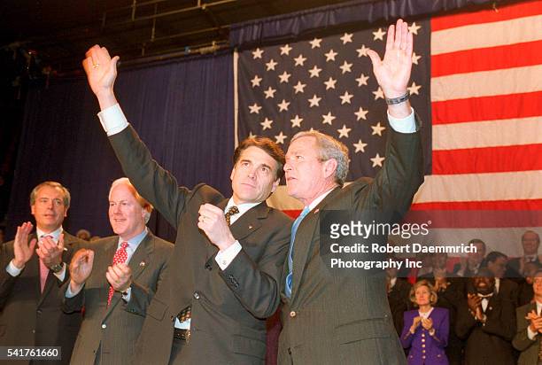 Texas Governor Rick Perry and President George W. Bush wave to supporters at campaign-ending Republican rally at Moody Coliseum in Dallas. Perry...
