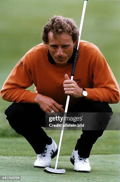 1957Golfspieler, Dmit Golfschläger in der Hocke auf demGrün- Juni 1997