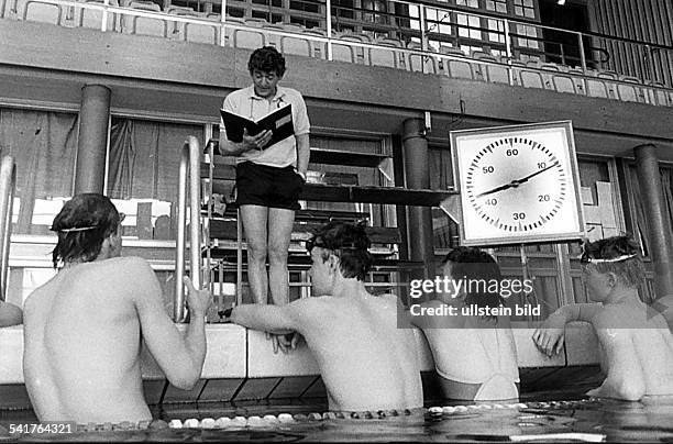 Trainer, Schwimmen DDRSchwimmtrainer vom SCE Dresden mit seinerSchwimmgruppe im Hallenbad: Neumann stehtam Beckenrand und liest aus seiner...