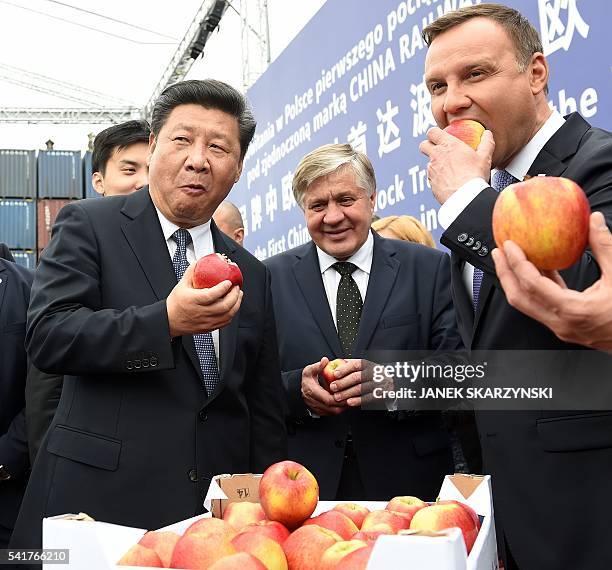 Chinese President Xi Jinping and Polish President Andrzej Duda eat Polish apples as they greet the arrival of the first China Railway Express train...