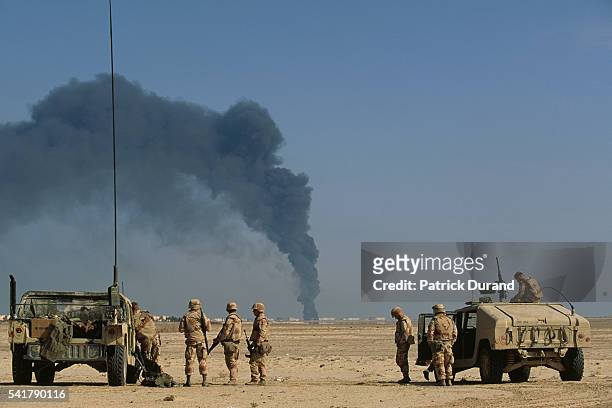 Soldiers arrive at a burning oil refinery in Al-Khafji, Saudi Arabia, near the Kuwait border, after Iraqi bombardment during the Gulf War. |...