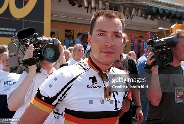 1970Sportler, Radrennen Dumringt von Kameramännern im Trikot desDeutschen Meisters vor dem Start derDeutschland-Tour in Berlin