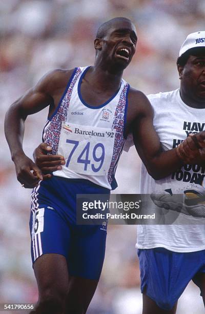 British athlete Derek Redmond is injured during the 1992 Barcelona Olympic Games and is supported by his father, Jim, who came onto the track during...