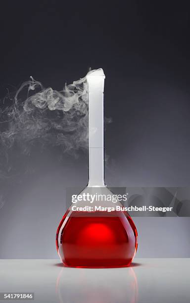 red chemical in beaker - chemische reaktion stock-fotos und bilder